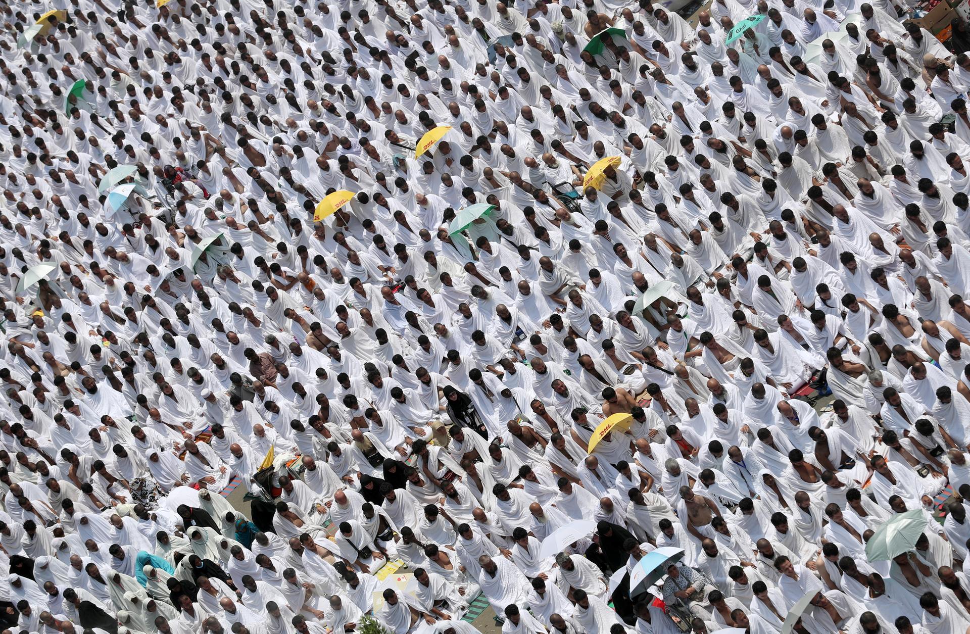 Muslim worshipers, some carrying umbrellas to protect them from the scorching sun, gather for prayer at Namirah mosque near Mount Arafat, also known as Jabal al-Rahmah (Mount of Mercy), where the Prophet Mohammed is believed to have given his final sermon, on August 31, 2017, ahead of the climax of hajj. Clad in white, their the palms facing the sky, some two million Muslims from around the world gathered on Saudi Arabia's Mount Arafat for the highlight of the hajj pilgrimage. / AFP PHOTO / KARIM SAHIB